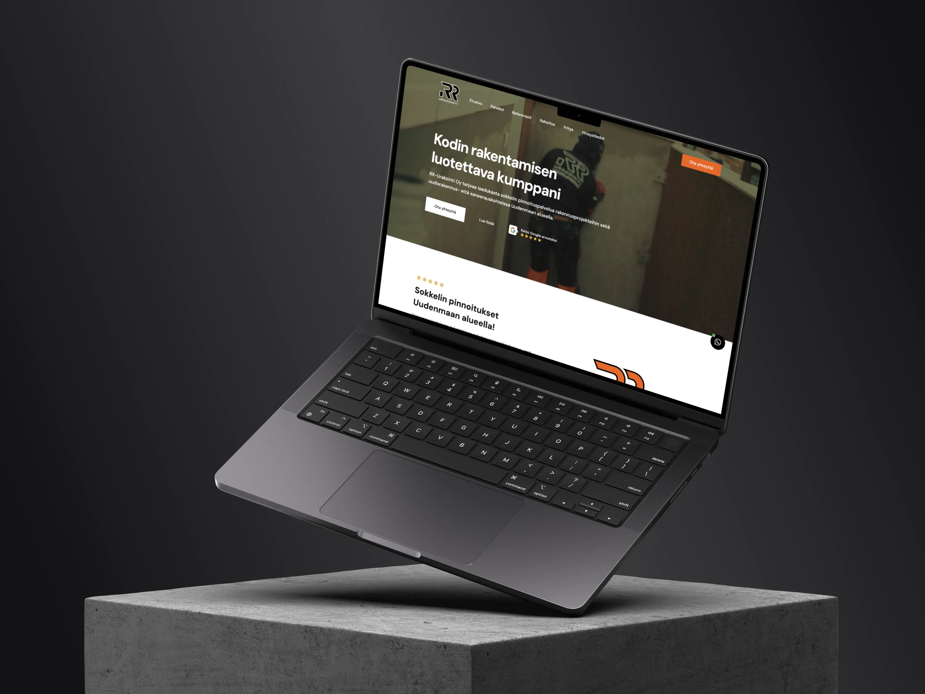 Harmaa kannettava tietokone betonijalustalla, näytöllä rakennusyrityksen verkkosivusto. Kirkas valaistus korostaa yksityiskohtia.
