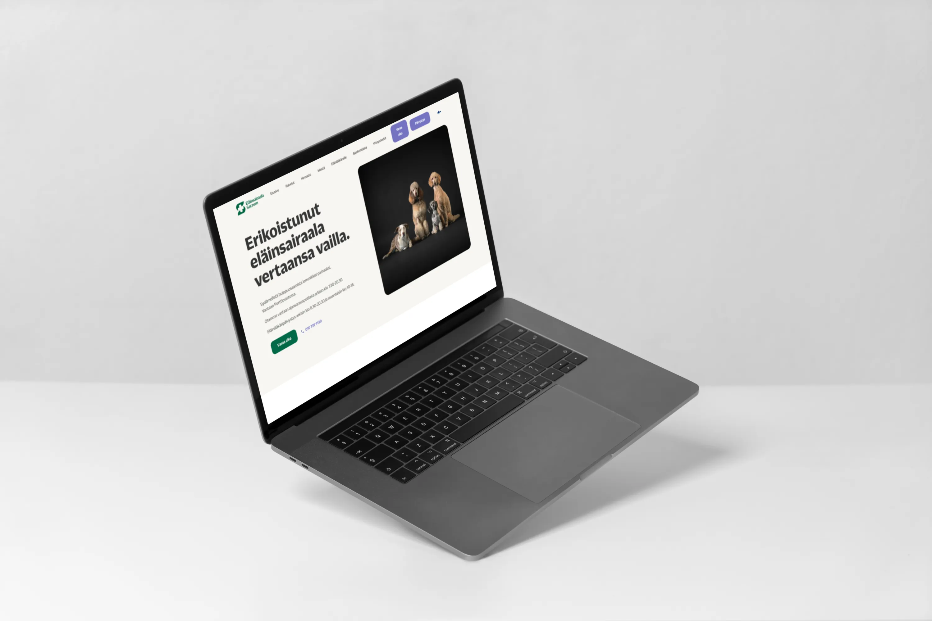 Kannettava tietokone, jossa näkyy eläinsairaalan verkkosivusto, valkoisella taustalla.